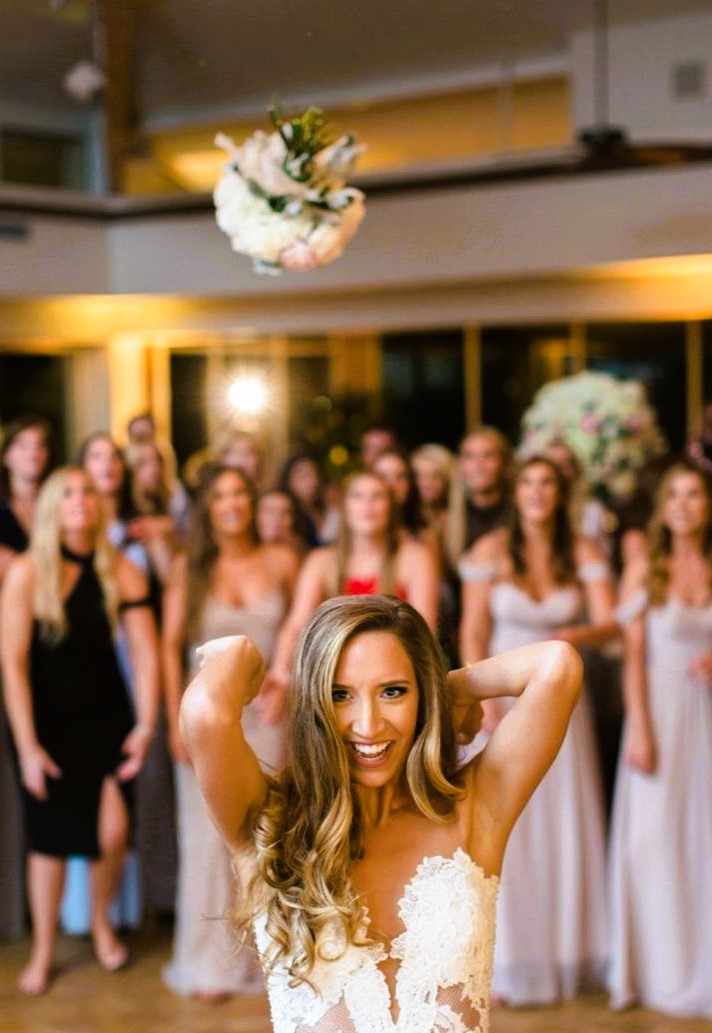 Bride tossing bouquet over shoulder