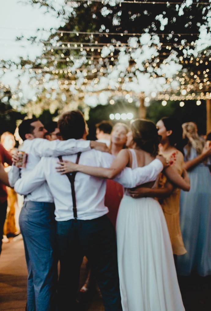 Couple with friends in group hugs