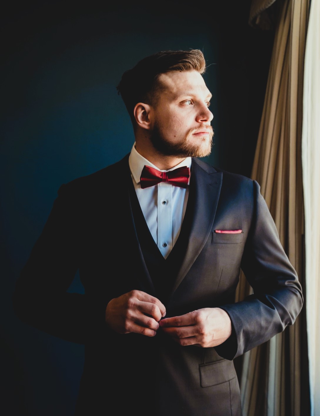 Groom standing by window